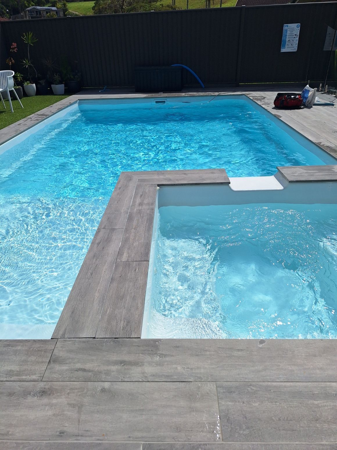 A pool filter is sitting in a shed next to a pump.