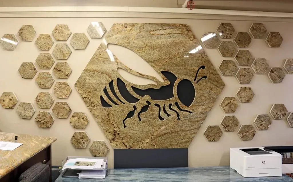 Honeycomb wall art with a large bee design in a modern office.