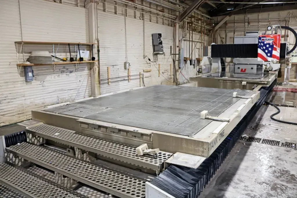 Stone cutting machine in a factory, with American flag.