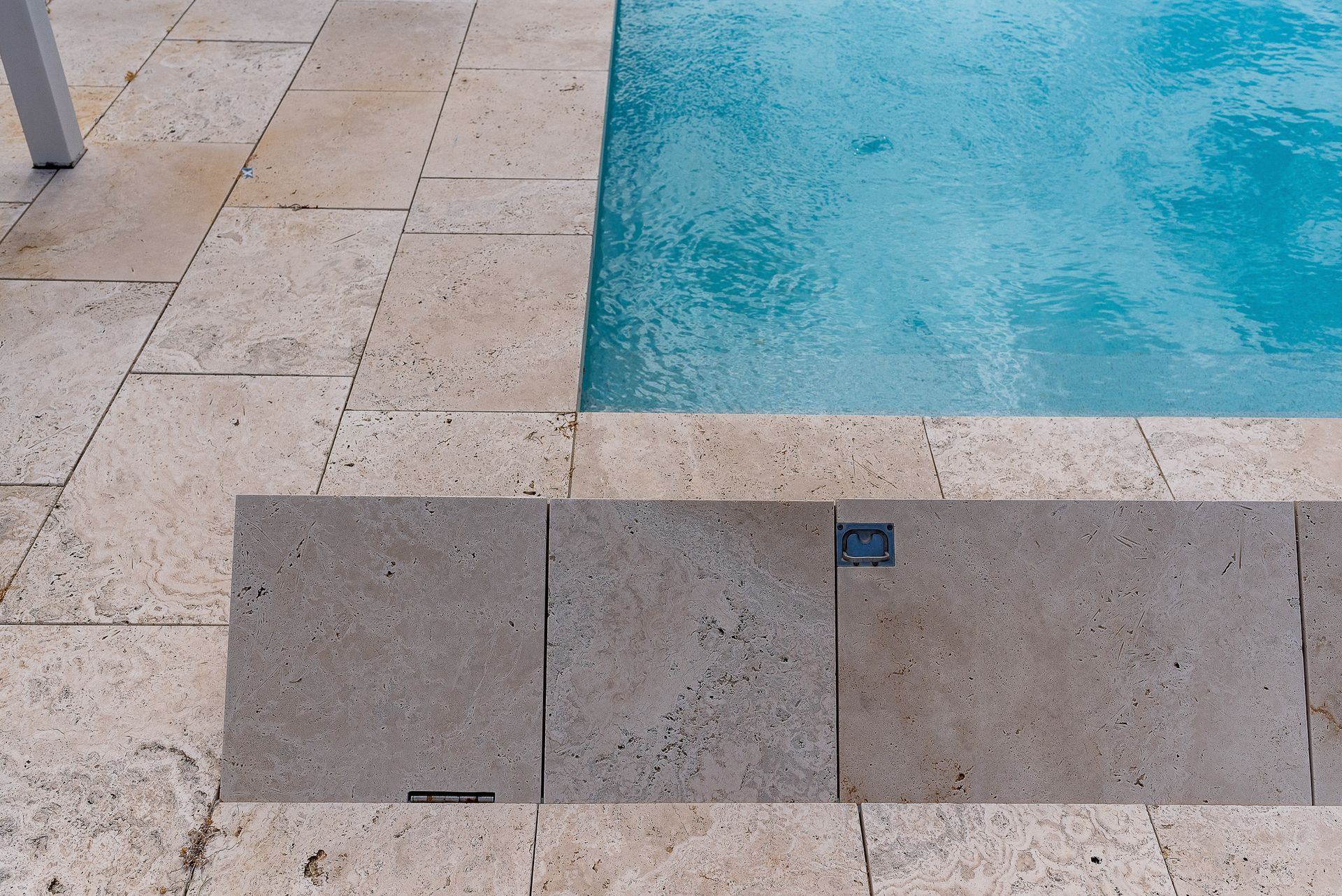 Gray composite deck with a dark, covered pool.