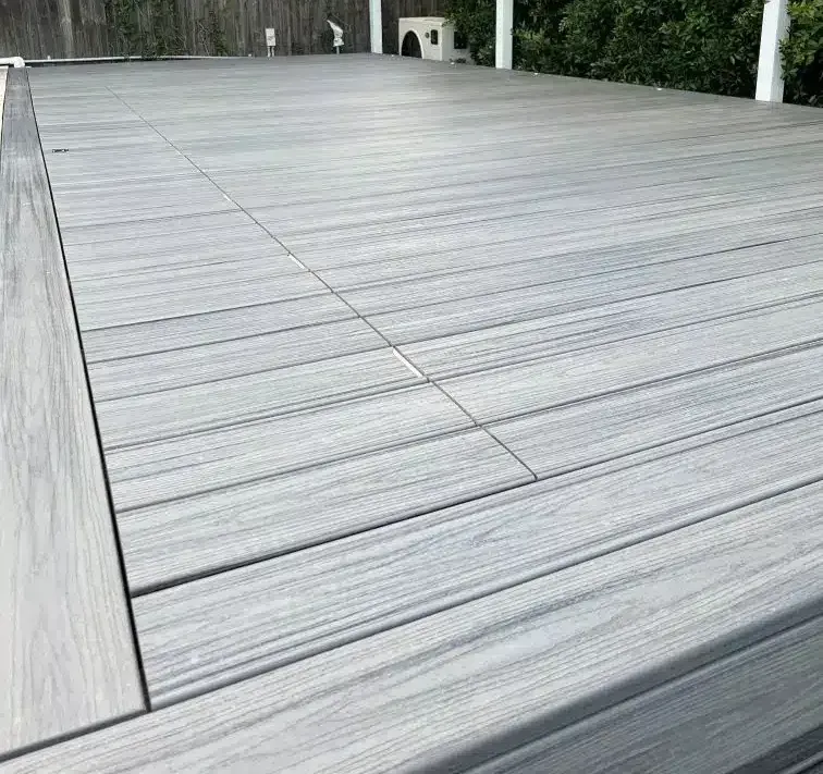 Gray composite deck with wood grain pattern, flat surface, built-in access panel.