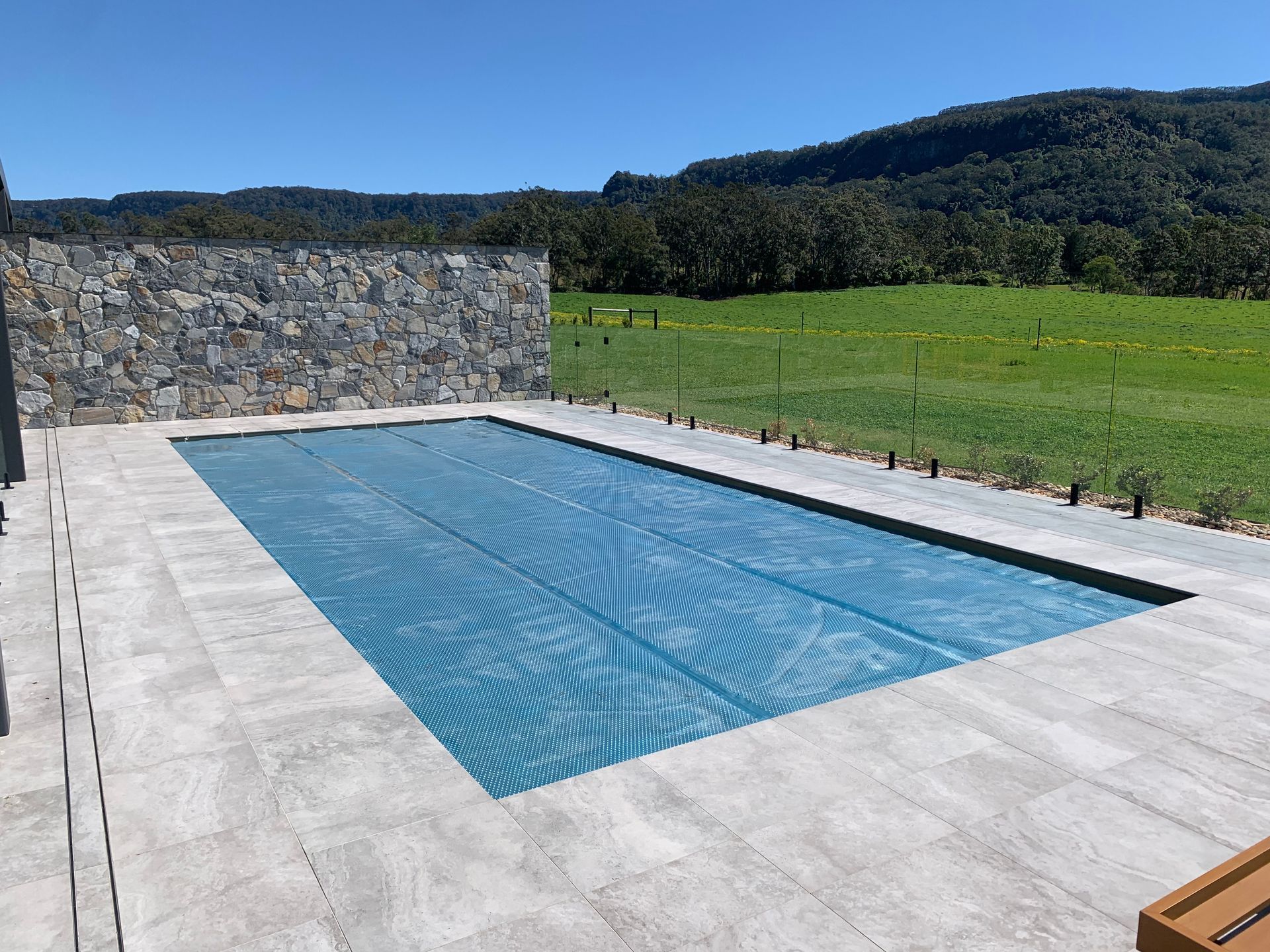 Gray composite deck with a dark, covered pool.