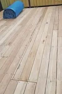 Light-colored wooden floor with a rolled-up blue mat in the background.