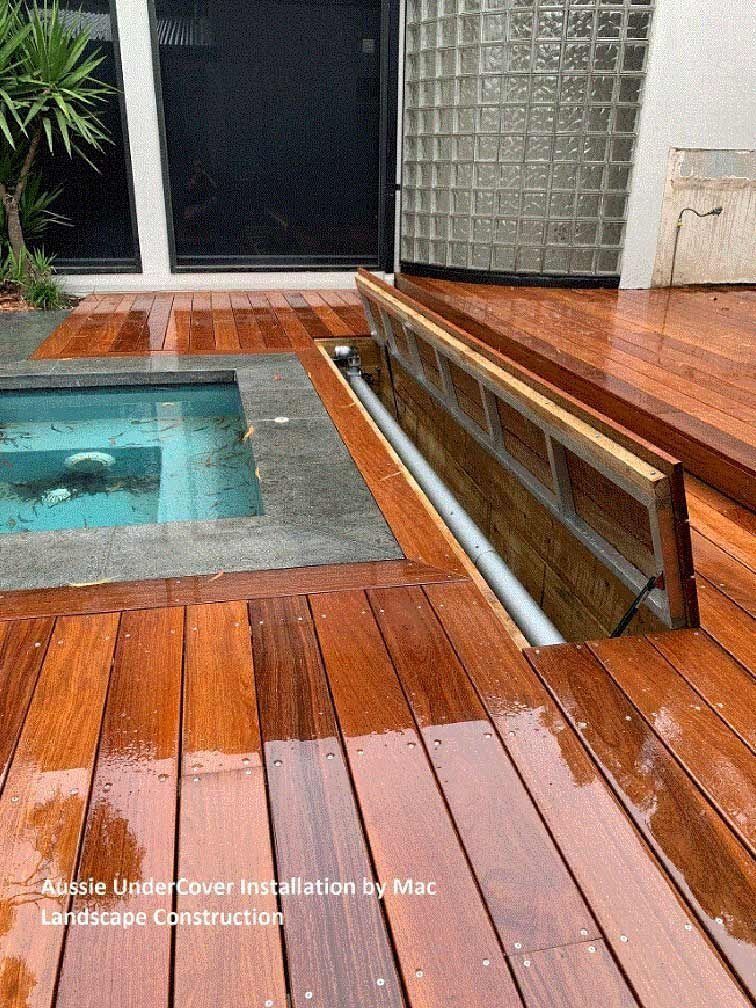 Wooden deck with a built-in cover over a submerged pool.