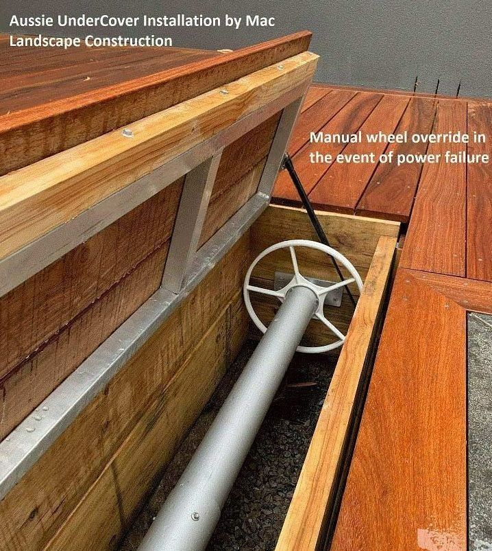 A manual override wheel inside a wooden deck for use during power failure.