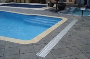 Swimming pools with a light-colored border, a metal track is laid out on the pavement.