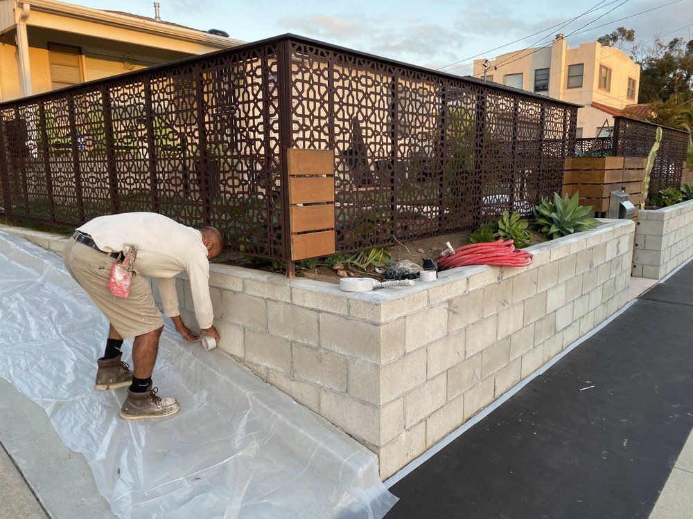 A man is painting a brick wall with plastic wrap.