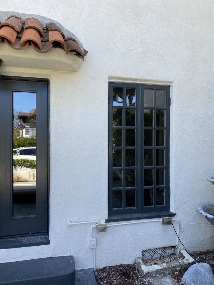 A white house with a black door and a black window.
