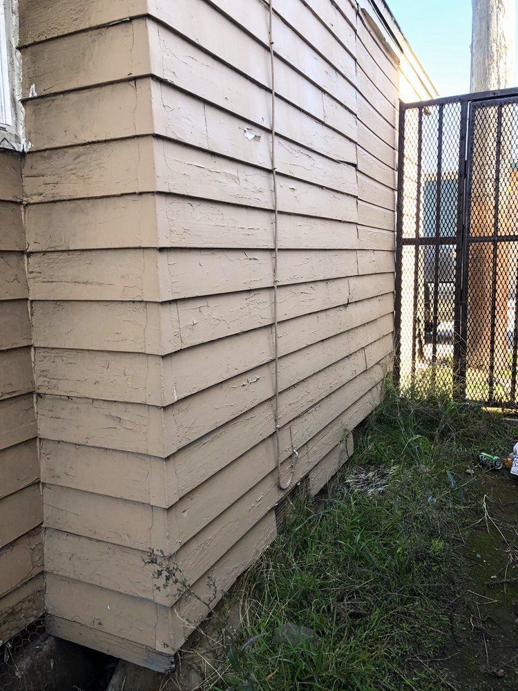 The side of a building with a fence in the background.