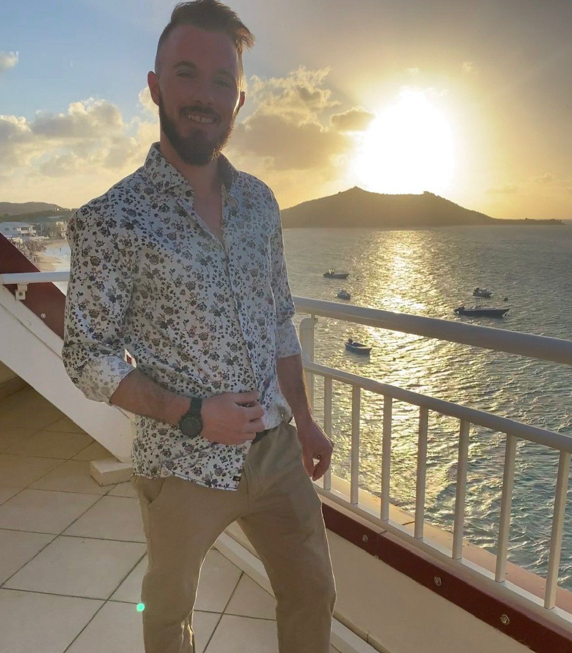 Un homme debout sur un balcon surplombant l'océan