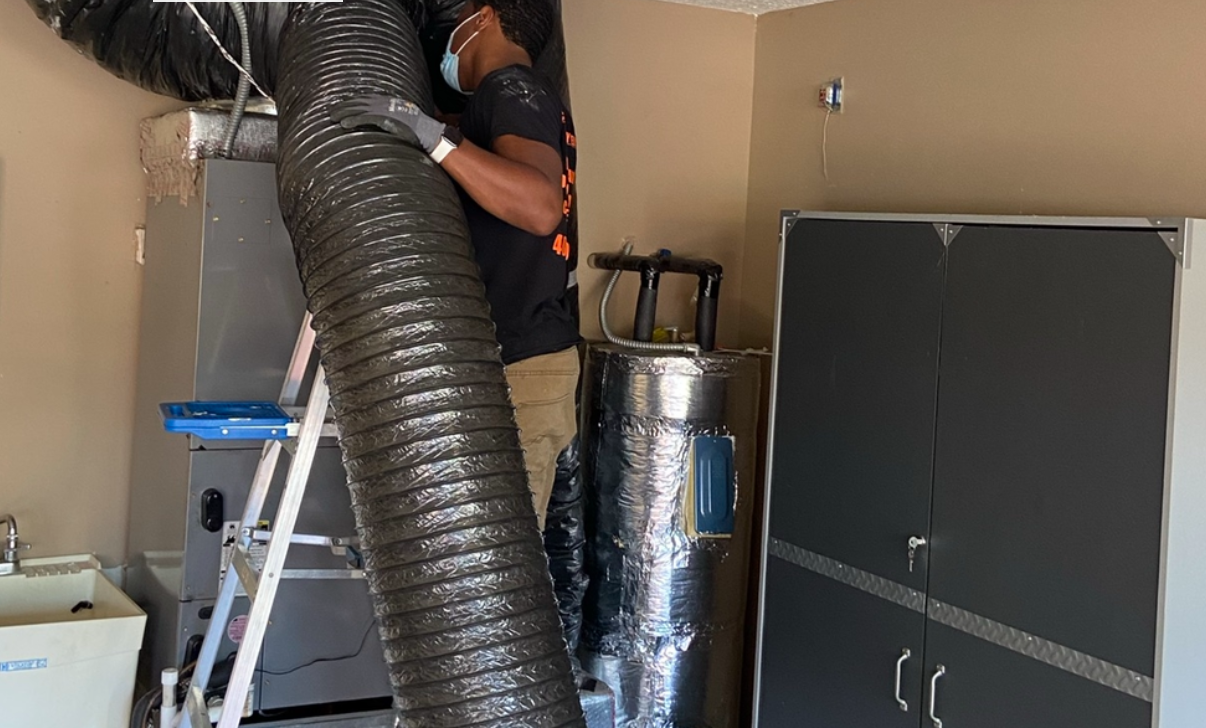 A man is standing next to a large hose in a room.