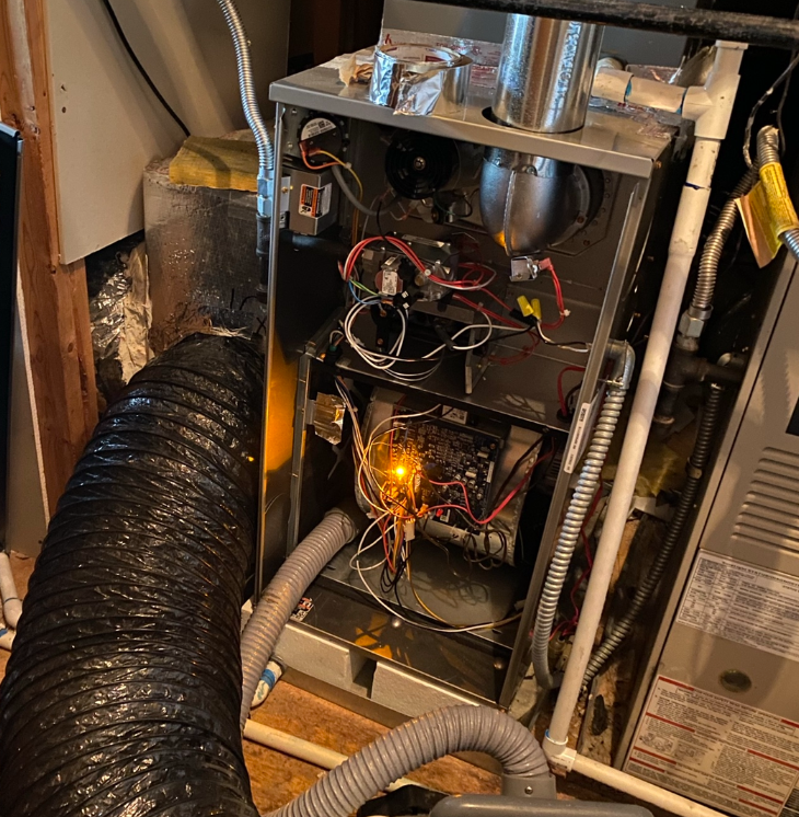 The inside of an air conditioner with a vacuum hose attached to it.