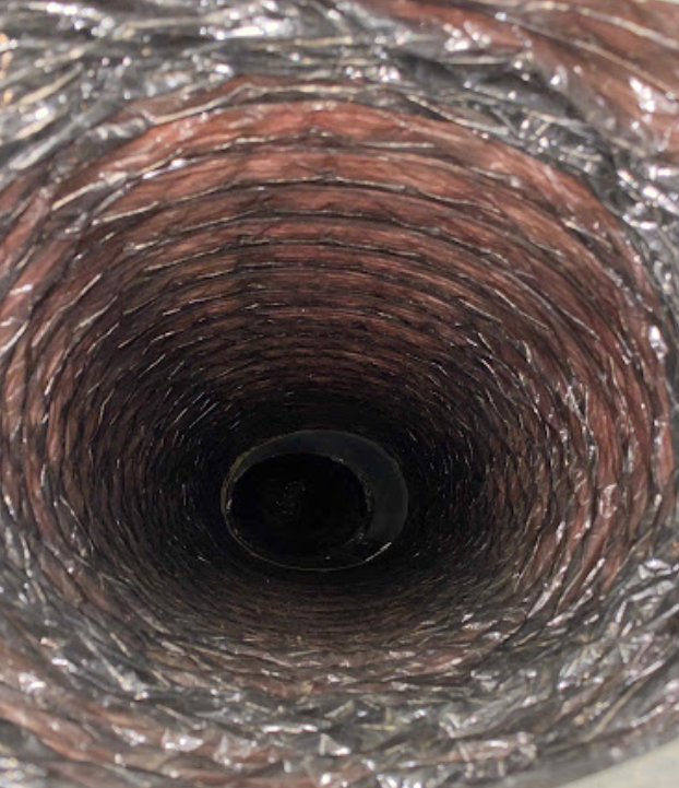 A close up of the inside of a duct with a hole in the middle.