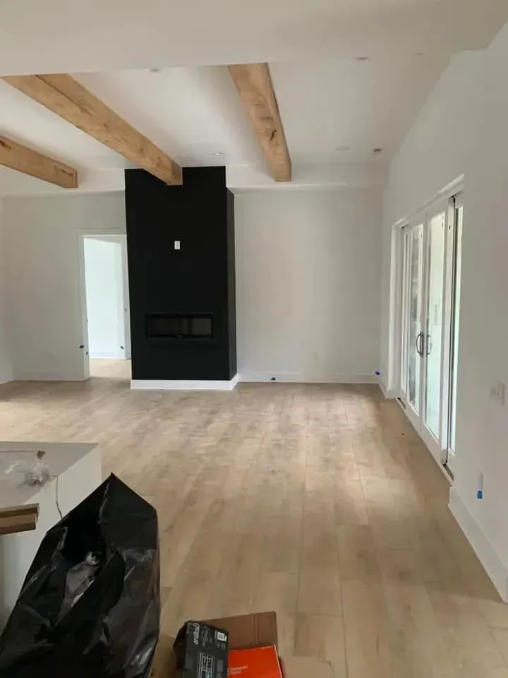 An empty living room with hardwood floors and a fireplace.