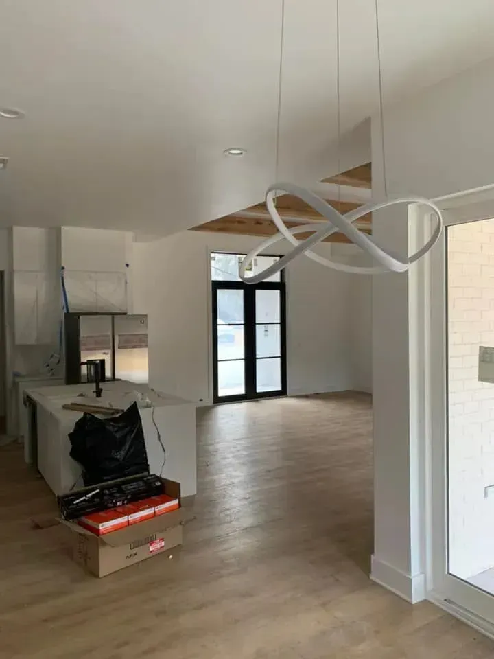 A large empty room with hardwood floors and a sliding glass door.