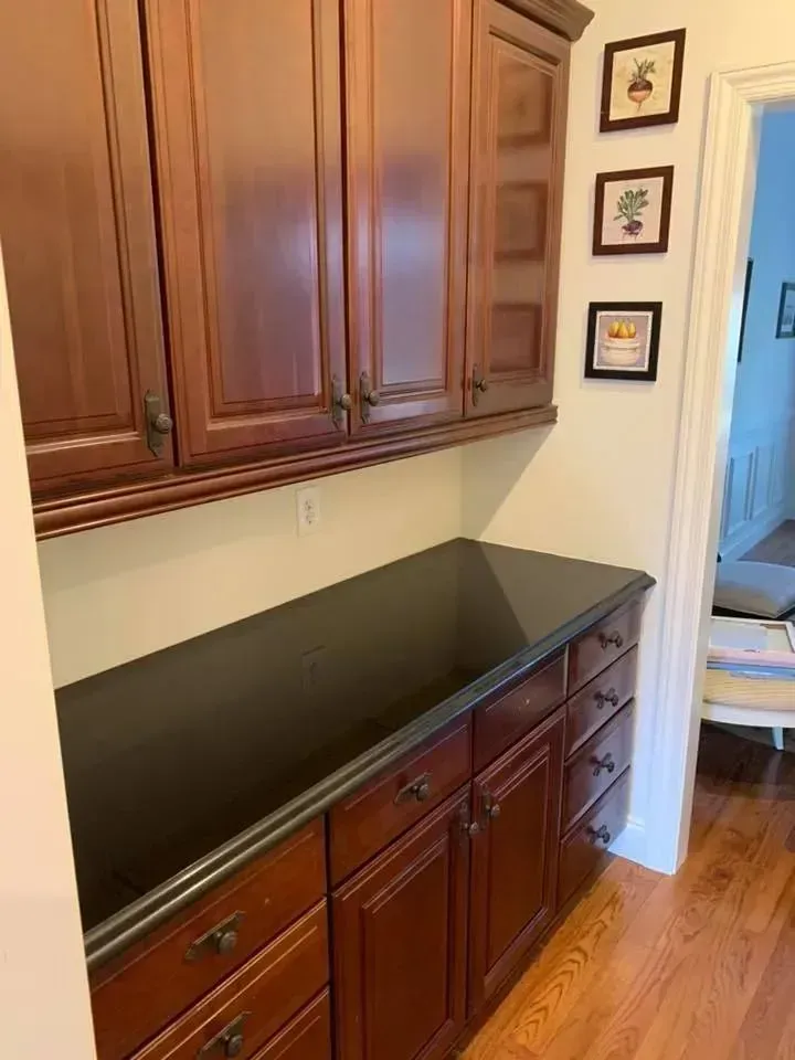 A kitchen with wooden cabinets and a black counter top.