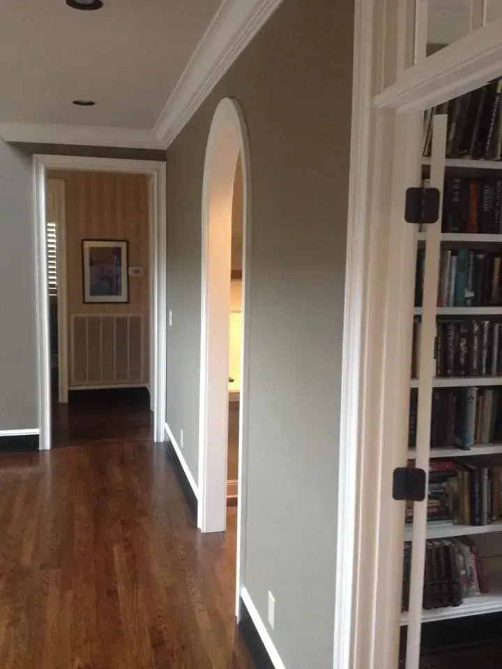 A hallway with a bookshelf and a picture on the wall