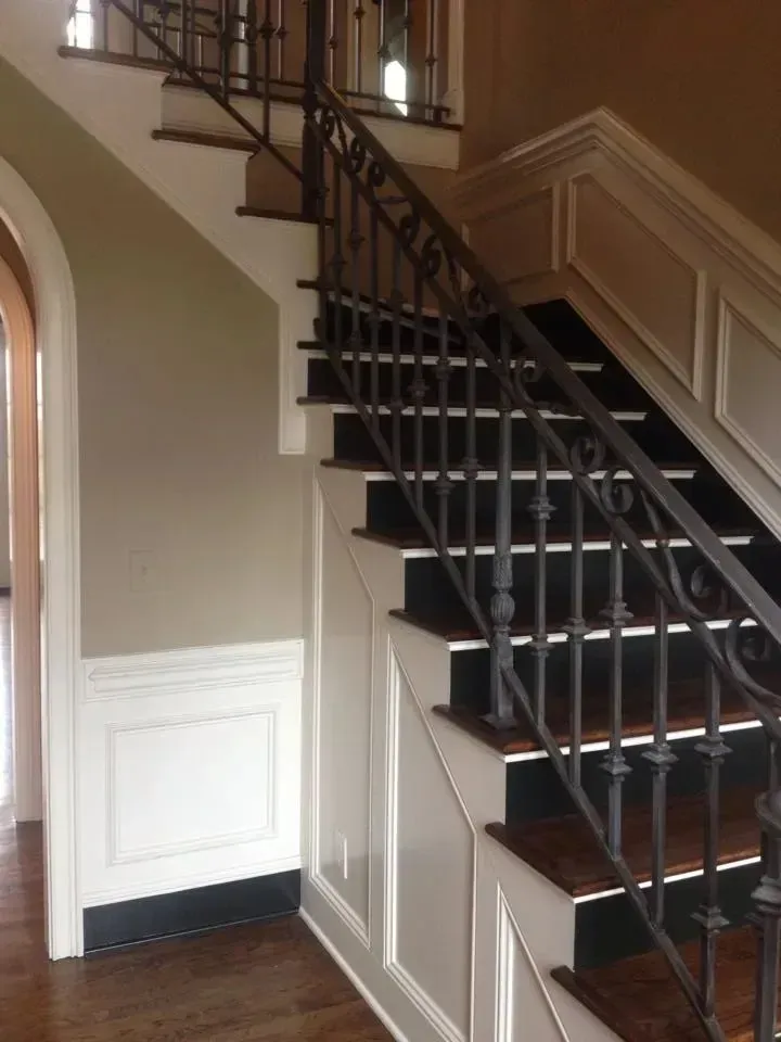 A staircase with black steps and a wrought iron railing