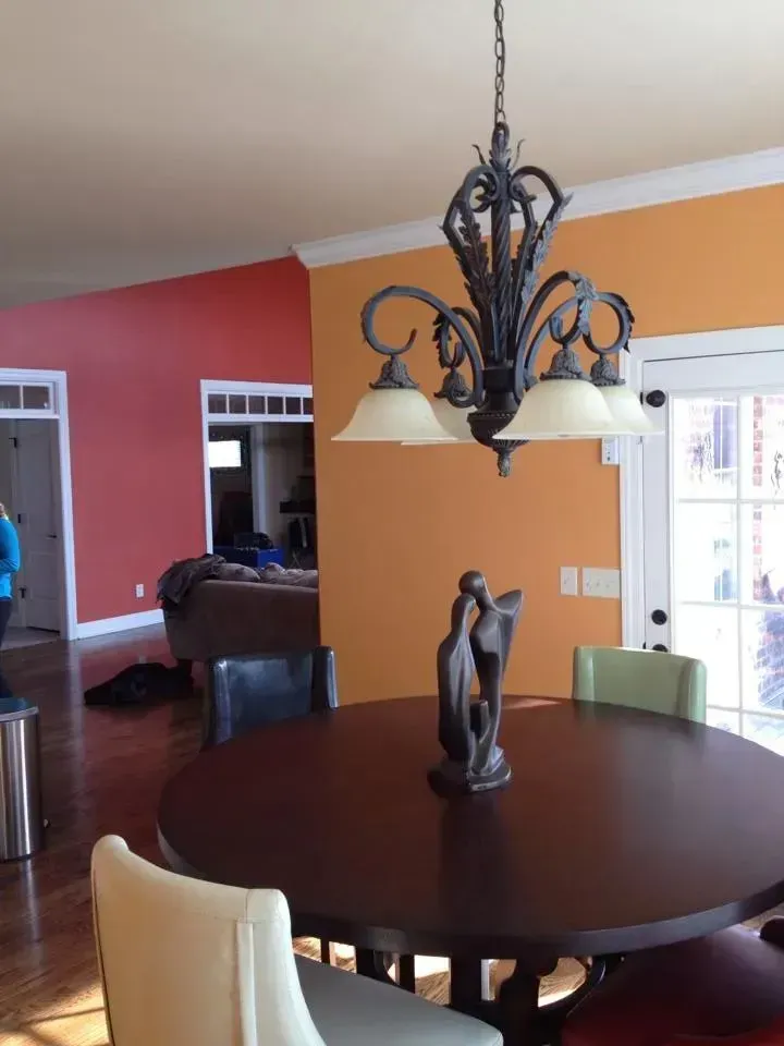 A dining room with a table and chairs and a chandelier hanging from the ceiling
