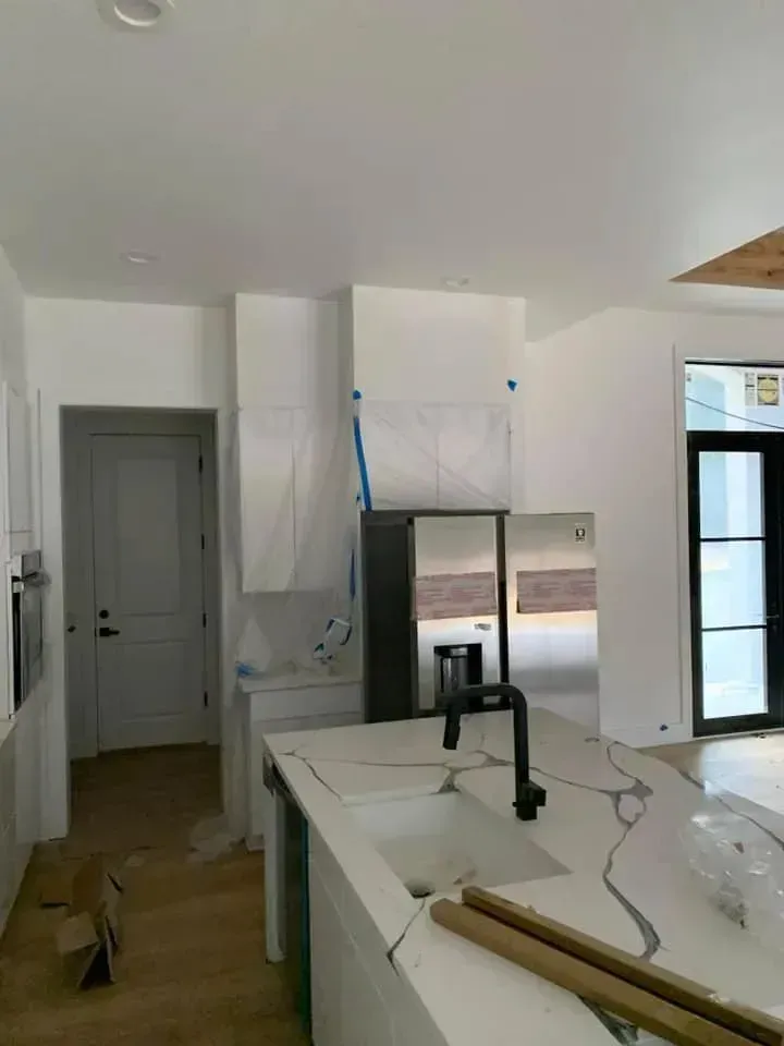 A kitchen with a sink , refrigerator , and stainless steel appliances.