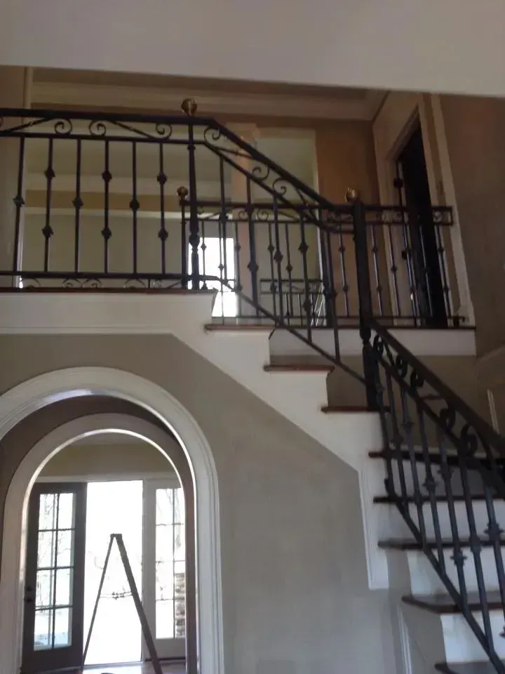 A staircase with a wrought iron railing leading up to the second floor