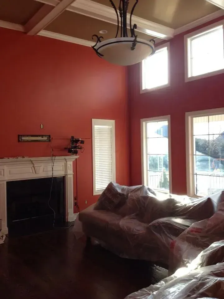 A living room with red walls and a fireplace