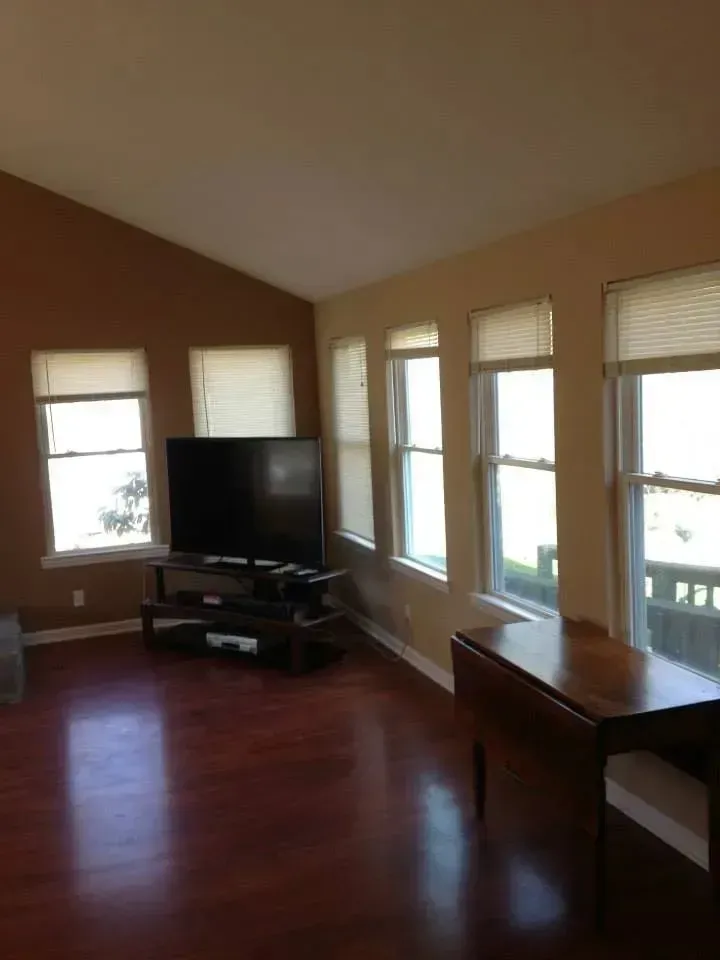 A living room with lots of windows and a flat screen tv