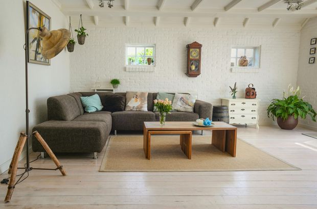 Cozy living room with a brown sectional sofa, wooden accents, and a jute rug.