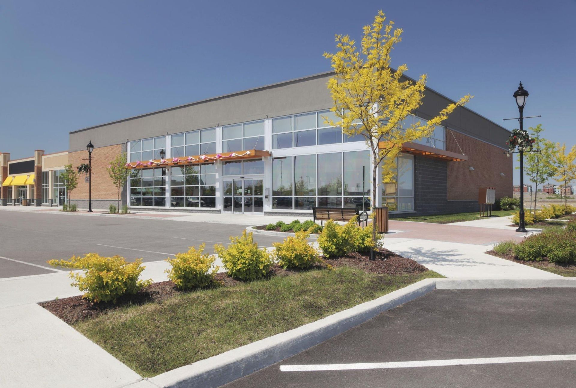 A large building with a lot of windows and a parking lot in front of it