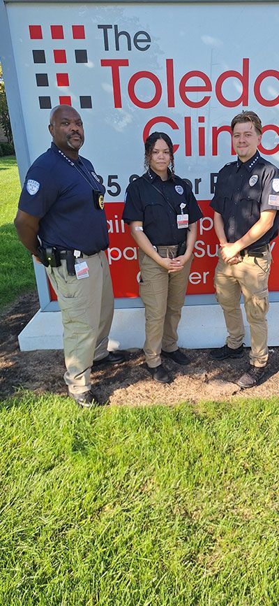 A group of security guards are standing in front of a sign.