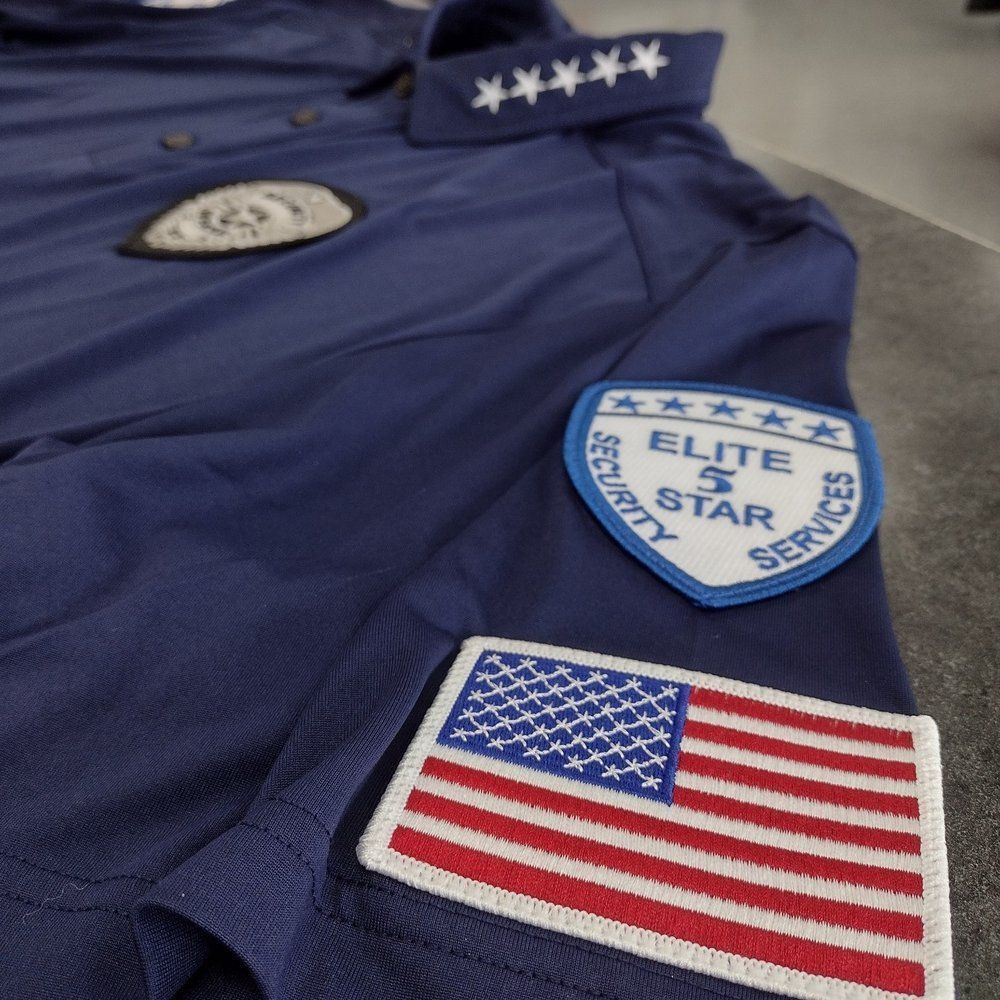 A blue shirt with a patch that says elite 5 star services