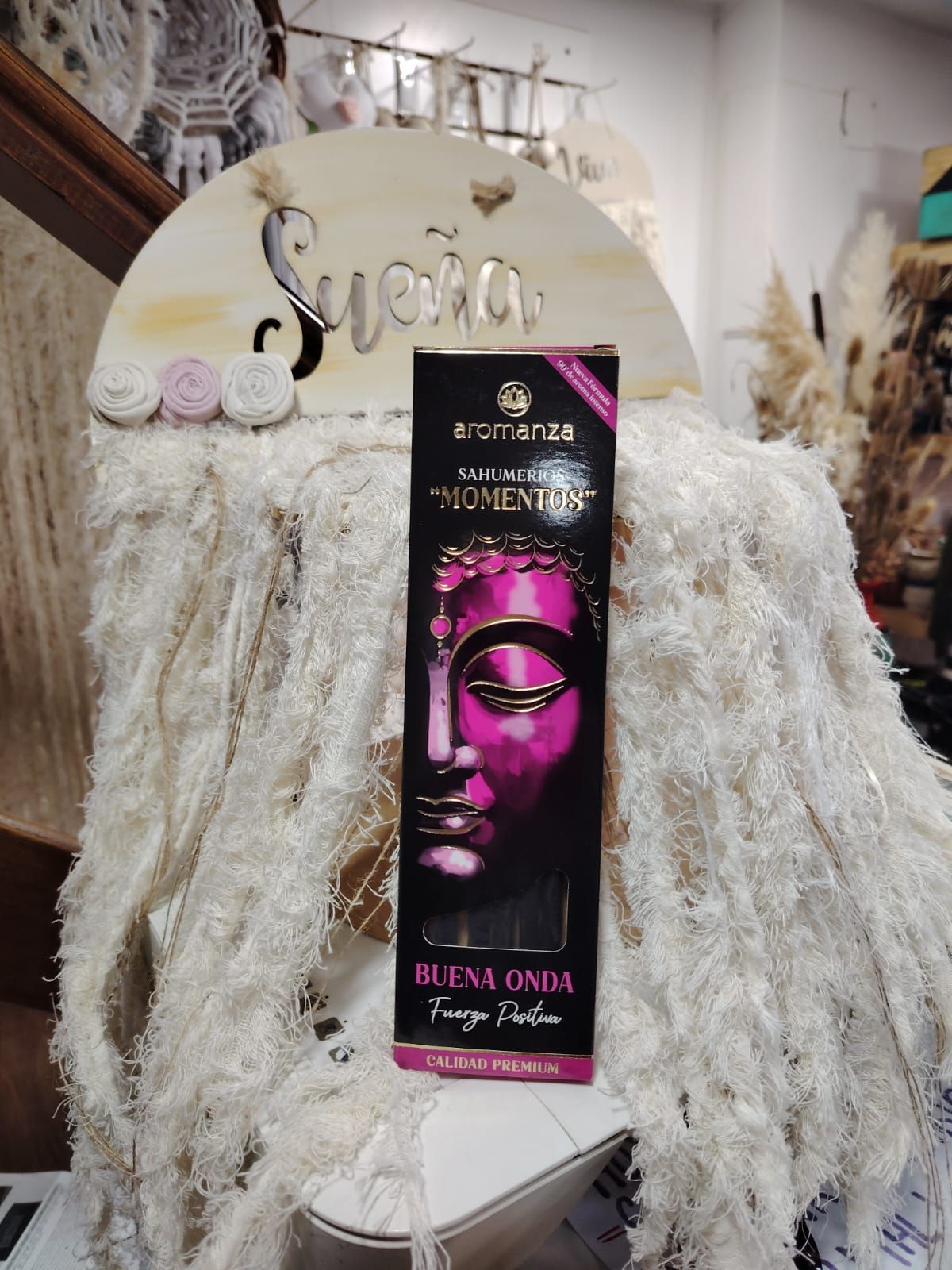 Varitas de incienso en una caja negra con una imagen dorada de Buda; etiquetada como 