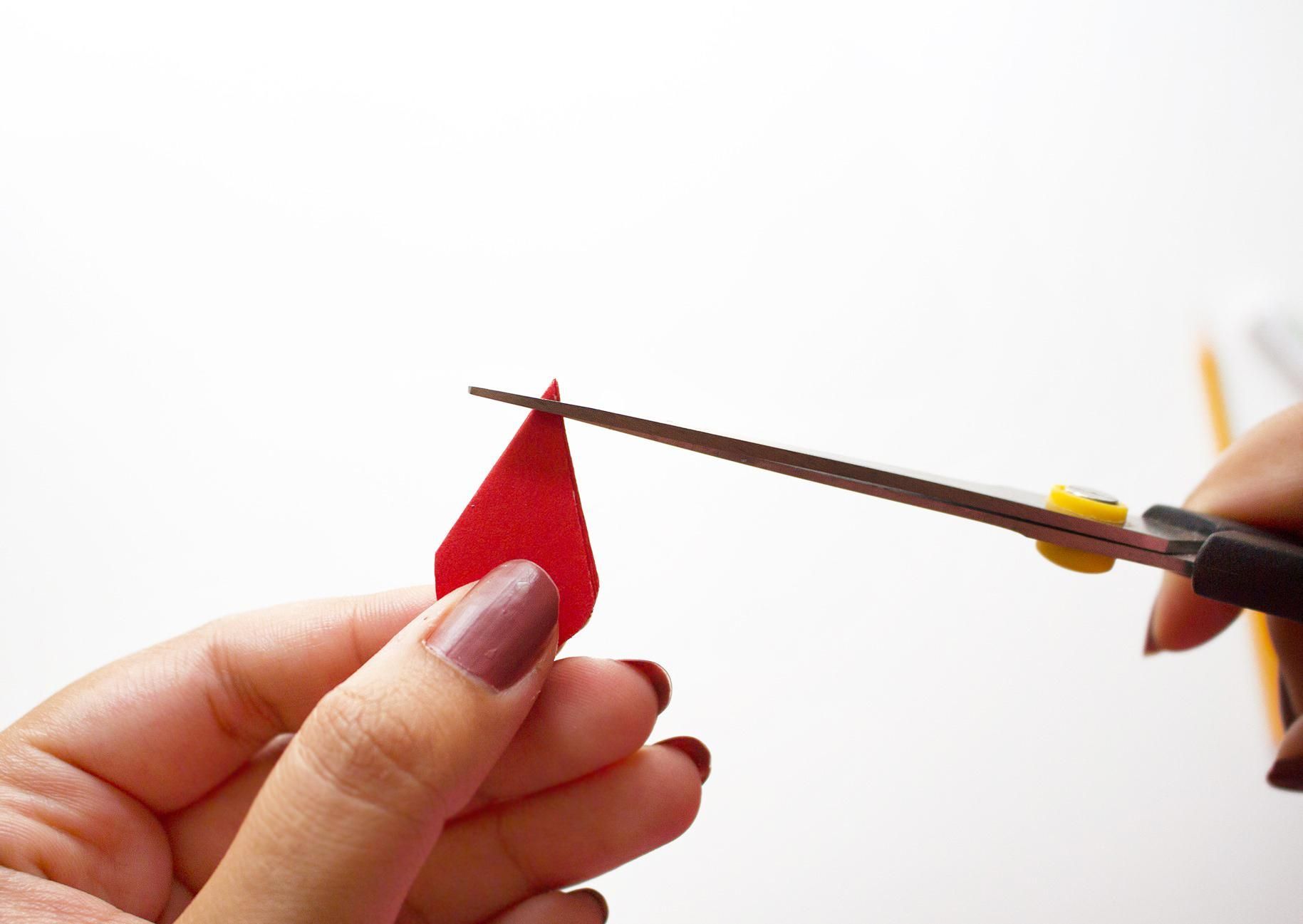 Woman cutting the bottom tip of the paper rose flower petal