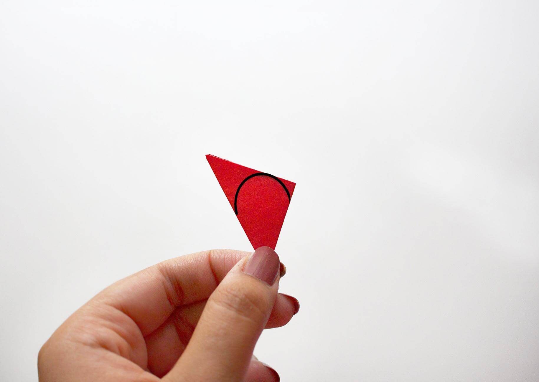 folded red paper with round shape drawn on it for cutting