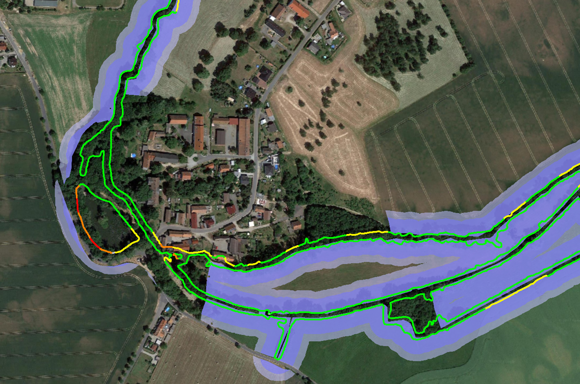 Eine Luftaufnahme eines Flusses mit einem Dorf im Hintergrund.