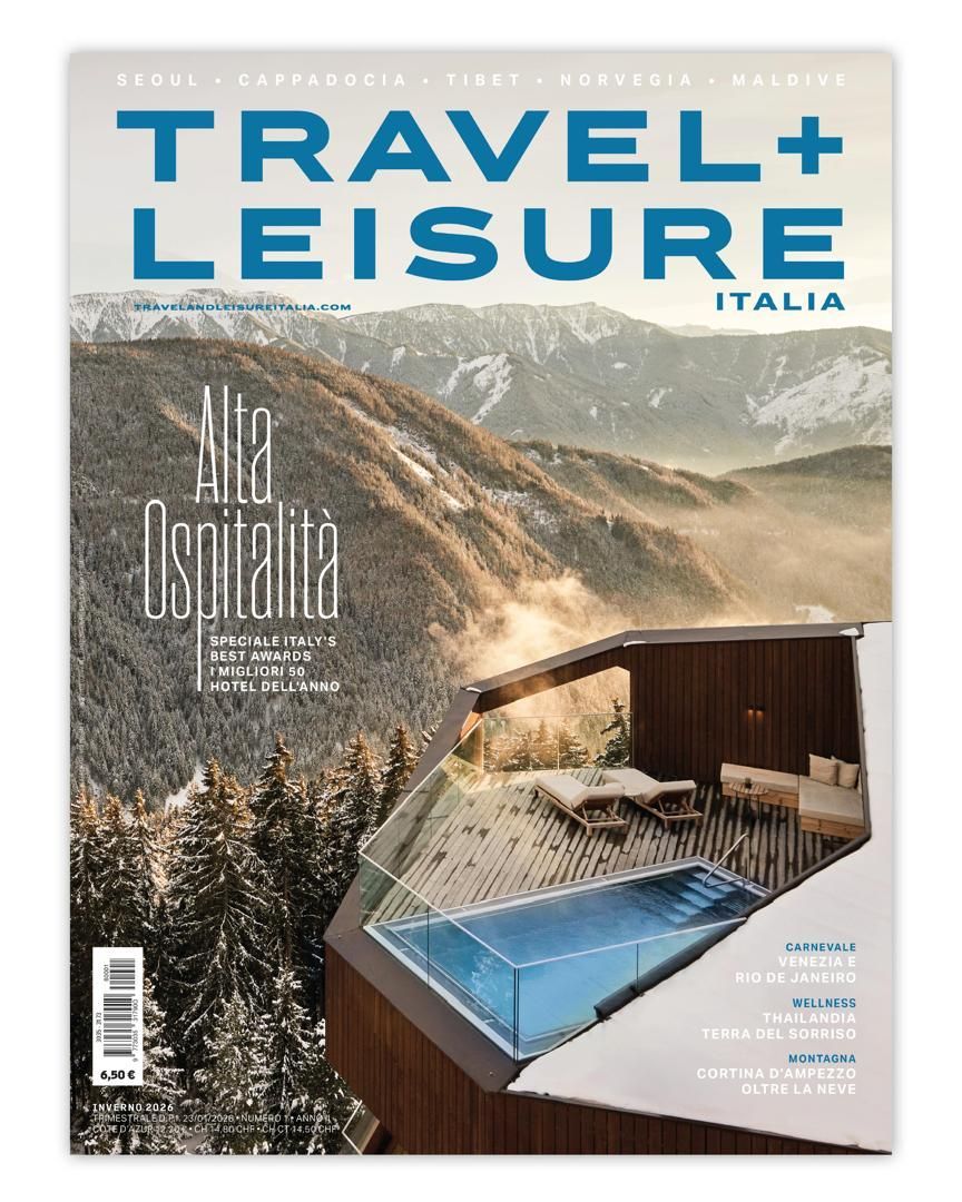 Couverture du magazine Travel + Leisure Italia avec une piscine donnant sur une chaîne de montagnes enneigées.