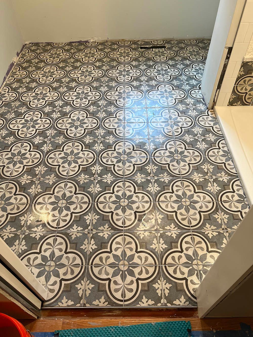 A black and white tile floor with a floral pattern in a bathroom.