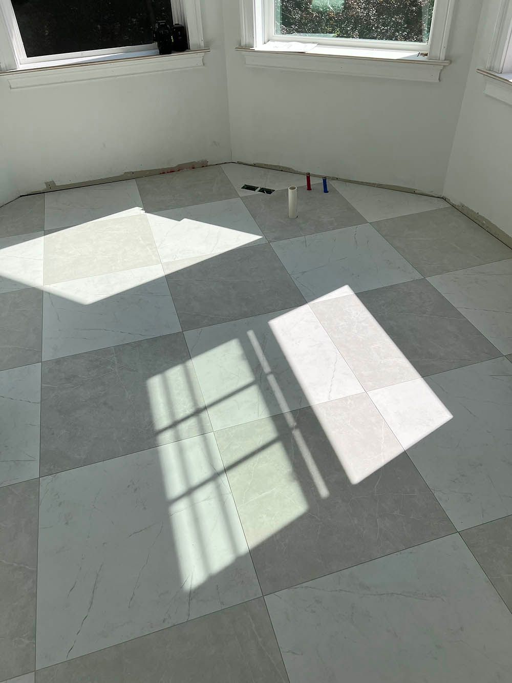 A room with a checkered floor and a window.