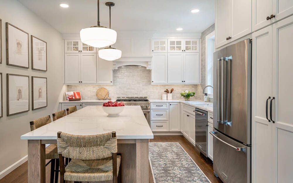 A kitchen with white cabinets and stainless steel appliances and a large island.