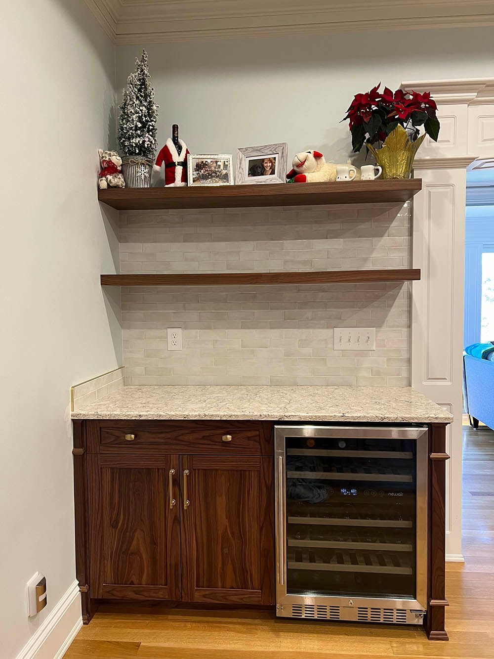 A kitchen with wooden cabinets and a wine cooler.