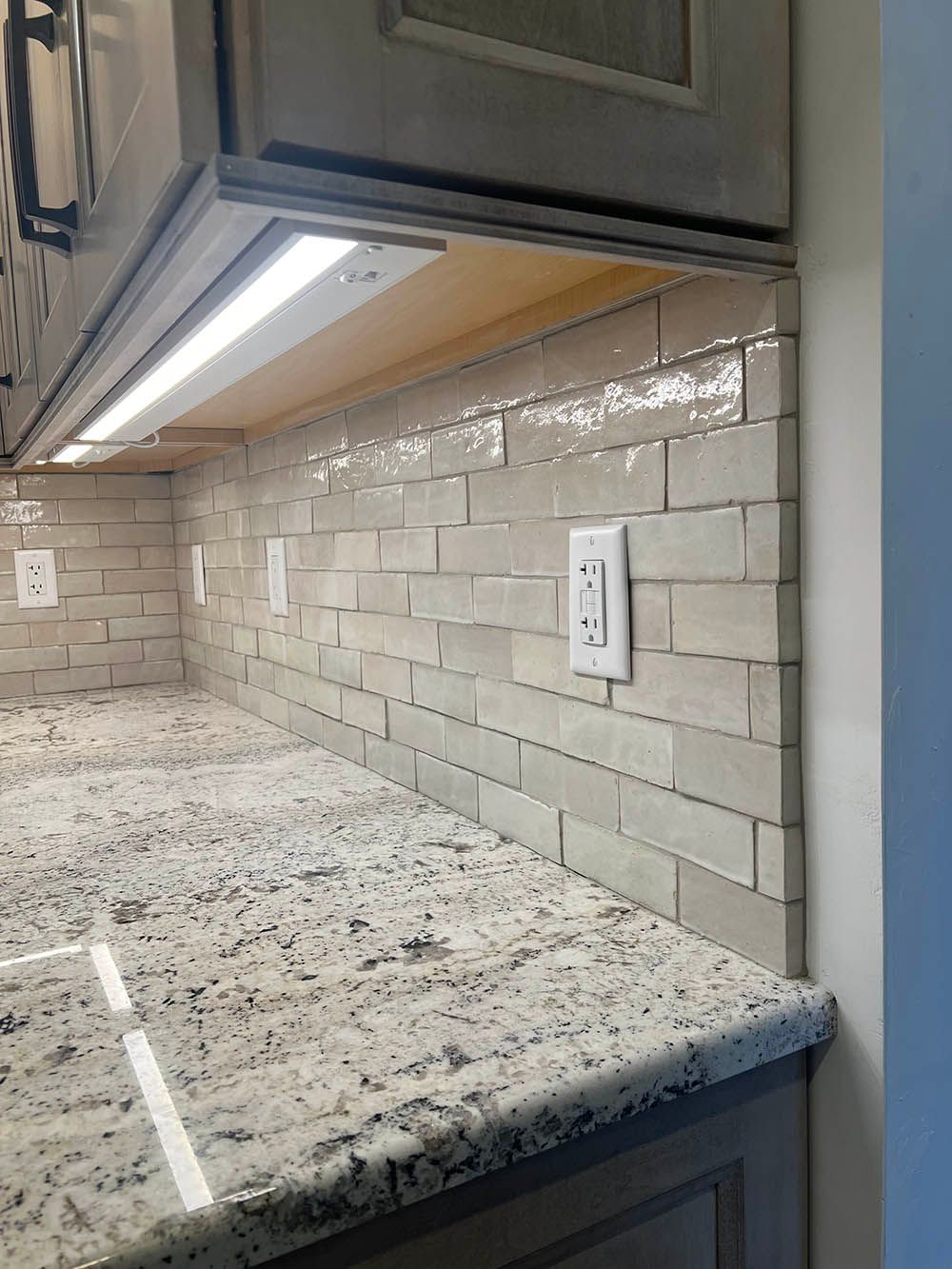 A kitchen with granite counter tops and a subway tile backsplash.