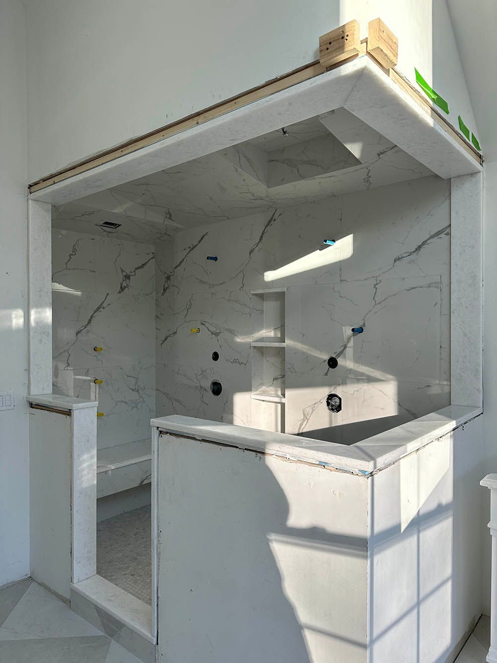 A bathroom with a marble counter top and a window