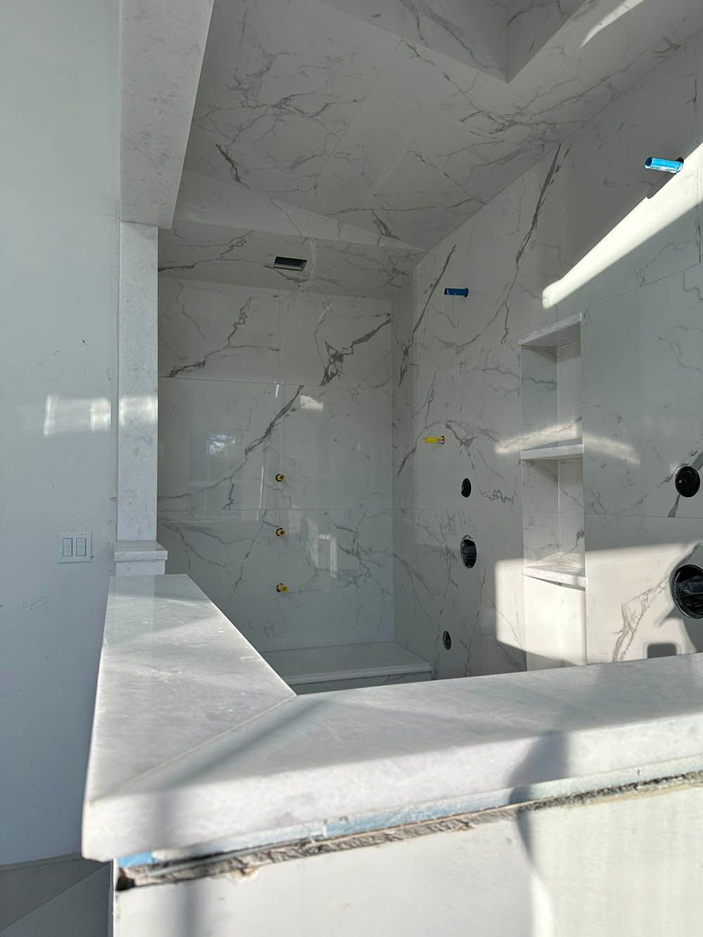 A bathroom with marble tiles and a marble counter top.