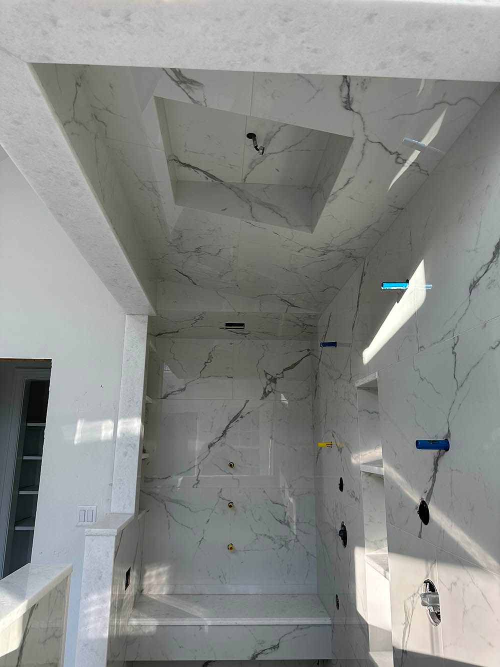 A bathroom with marble tiles on the walls and ceiling.