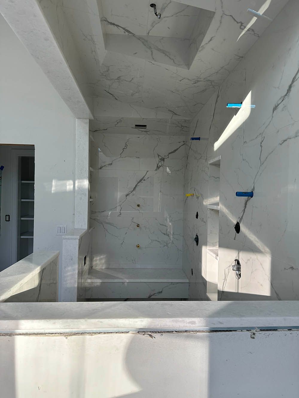A bathroom under construction with marble tiles and a bathtub.