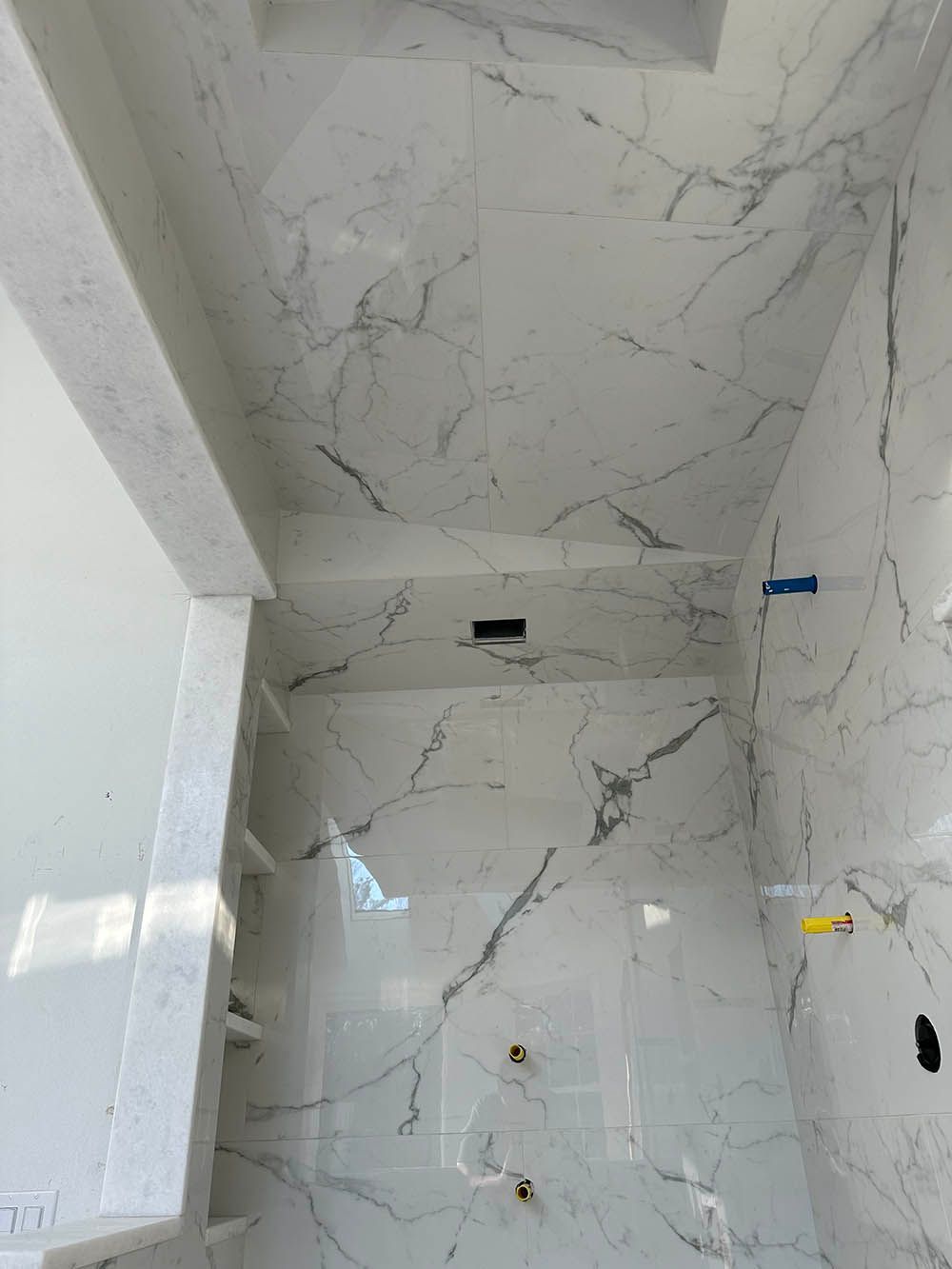 A bathroom with marble tiles on the walls and ceiling.