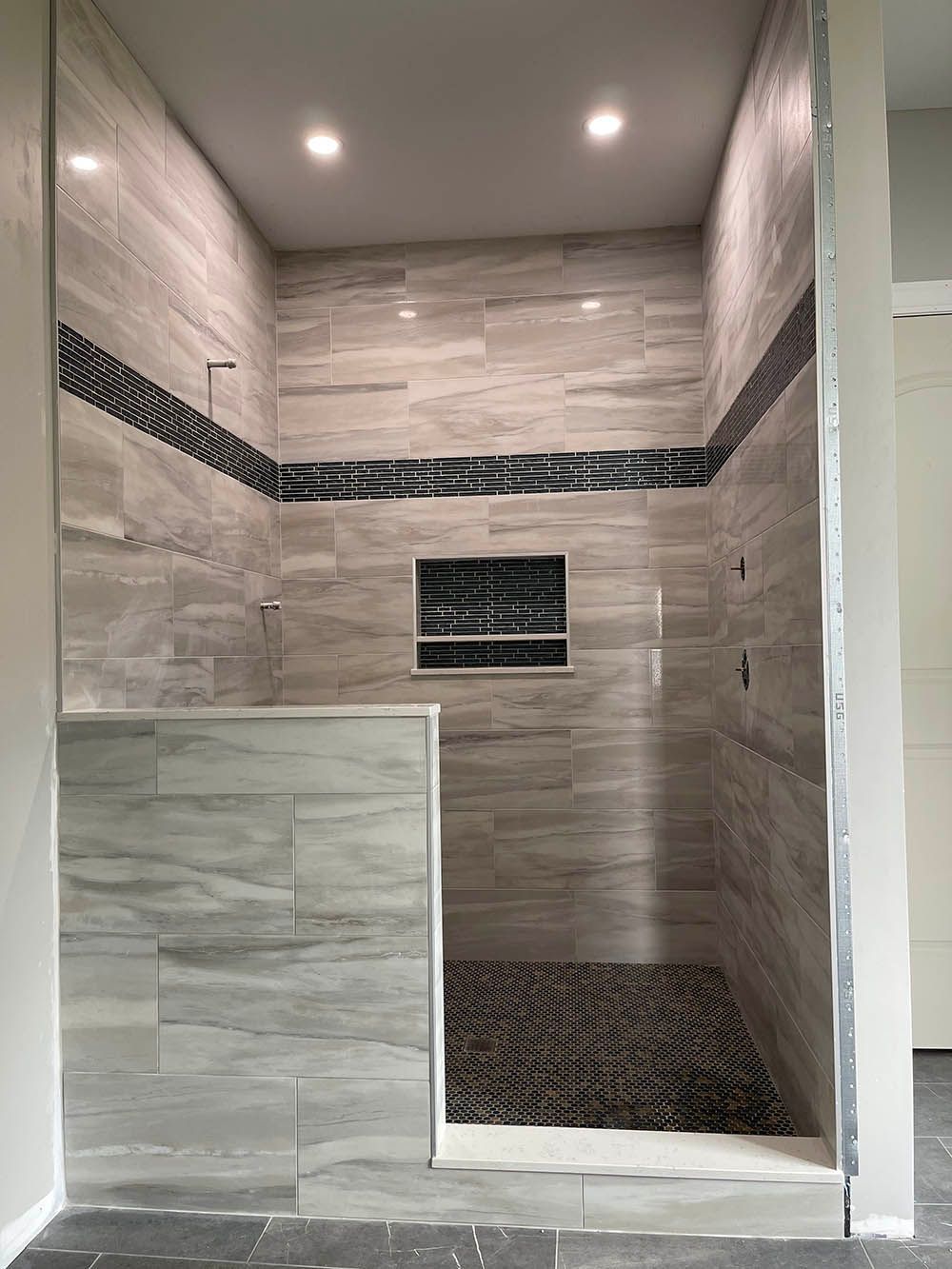 A bathroom with a walk in shower and tiled walls.
