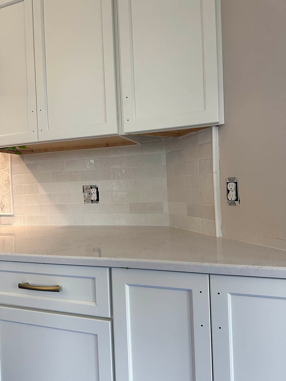 A kitchen with white cabinets and a white counter top.