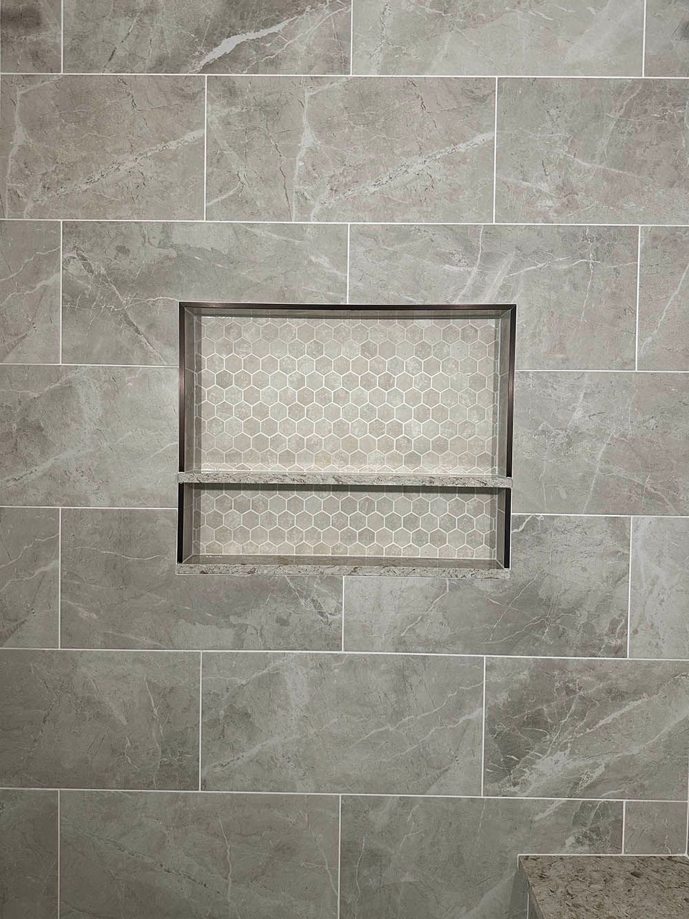 A shower niche is built into a tiled wall in a bathroom.