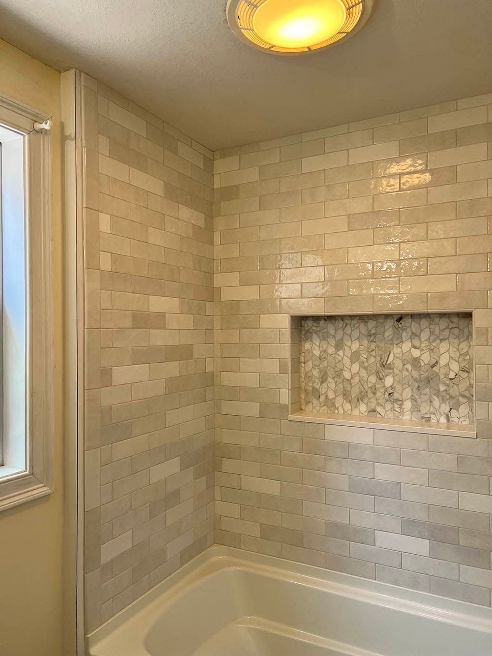 A bathroom with a bathtub and a brick wall.